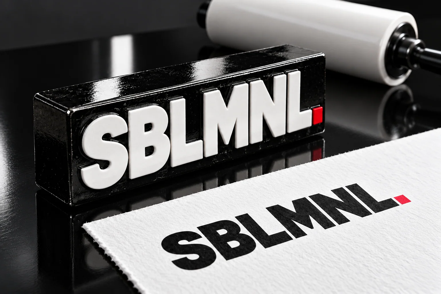 The SBLMNL wordmark making an impression on paper.